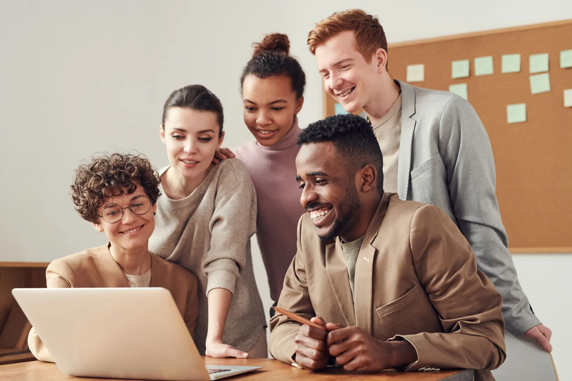 Équipe multiculturelle travaillant ensemble autour d'un ordinateur portable